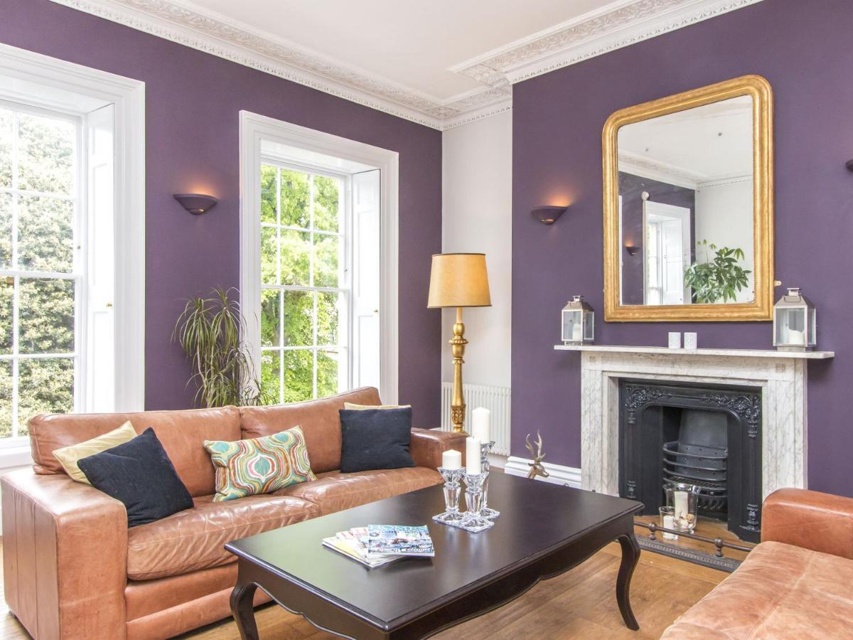 a living room with a couch and a mirror at 3 Berkeley Square Guesthouse in Bristol